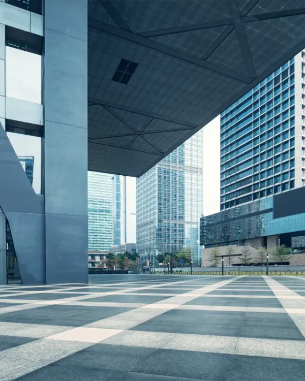 Large modern campus building with a stone-paved plaza