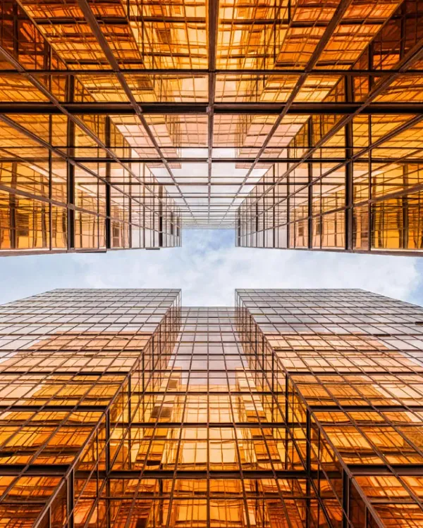 Glass office towers reflecting a warm orange sky