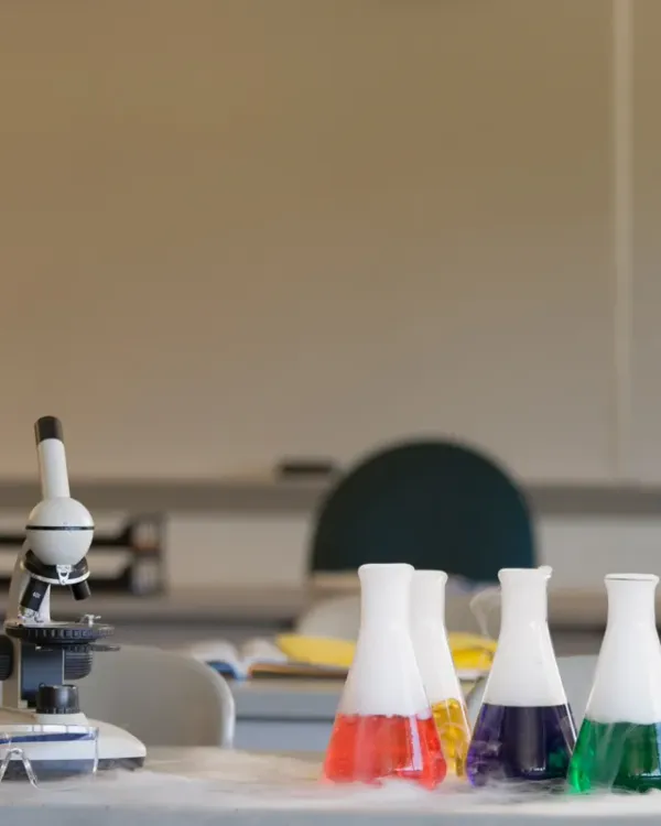 Laboratory bench with a microscope and flasks of coloured liquid