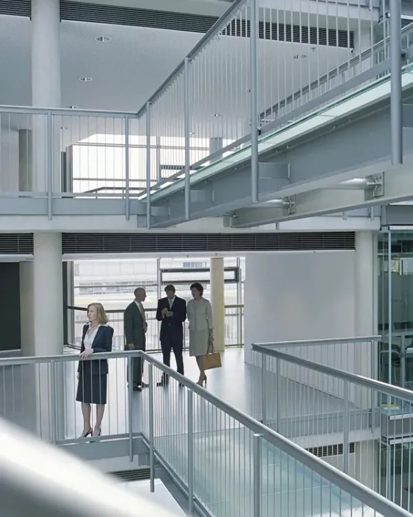 Business people talking on a walkway inside a modern office atrium