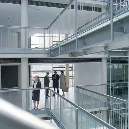 Business people talking on a walkway inside a modern office atrium